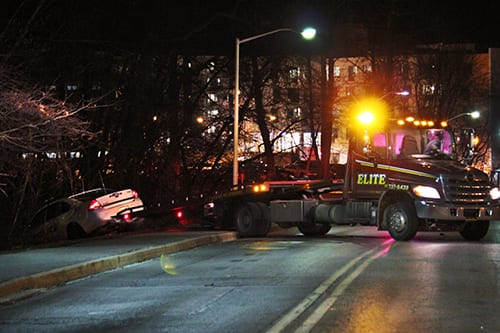 A Stony Brook Police Department cruiser is removed from a ditch near the Tabler Residence Quad after an officer struck a female student on the sidewalk. (ANUSHA MOOKERJEE / THE STATESMAN)