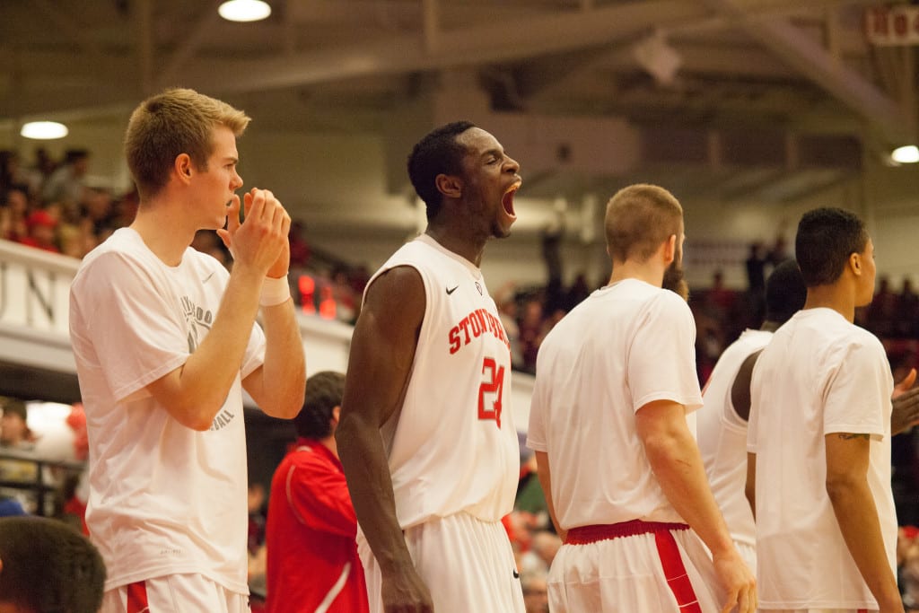 Roland Nyama cheers on his team after a Scott King three-pointer early in the second half. HEATHER KHALIFA / THE STATESMAN