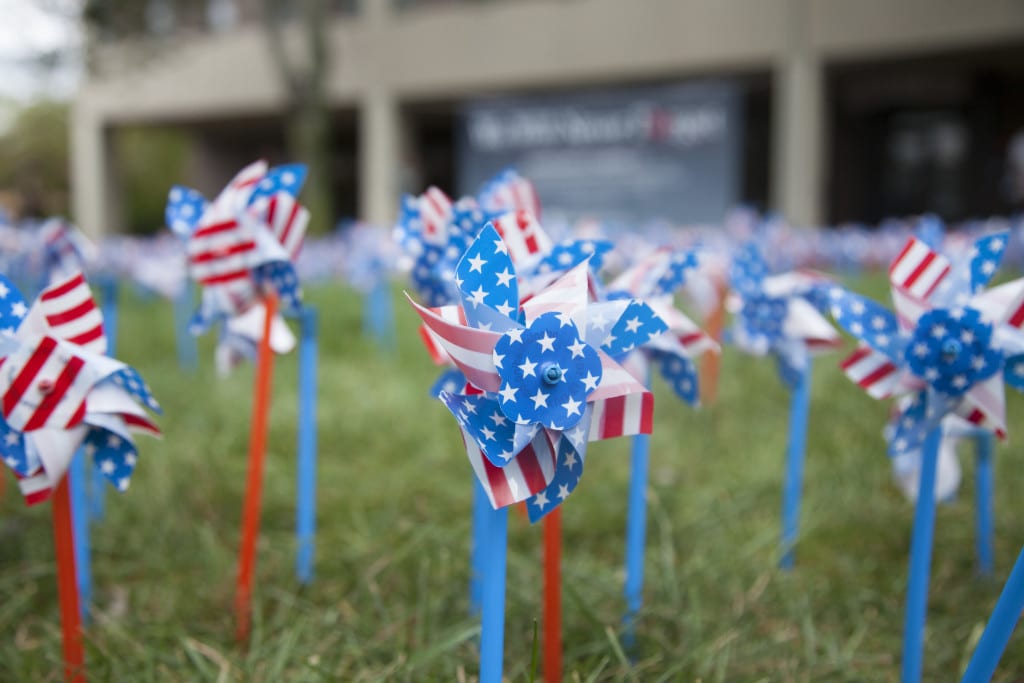 Students can stop by and place a pinwheel on the grass throughout the day. ERIC SCHMID/THE STATESMAN
