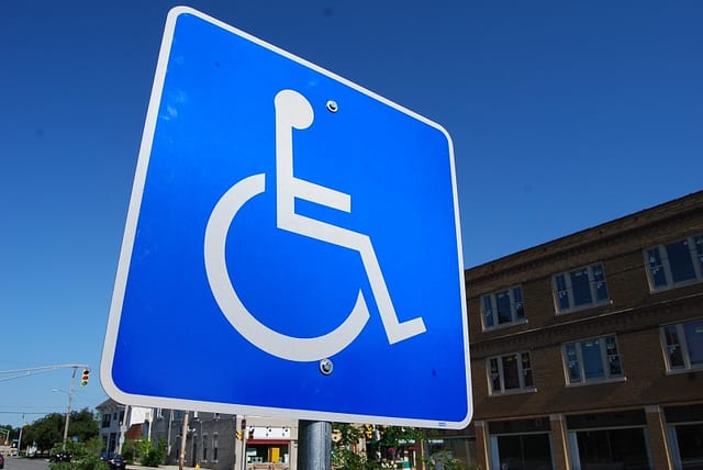 A parking lot handicap sign. According to the World Health Organization, over 1 billion people, about 15% of the worlds population, lives with some form of disability. STEVE JOHNSON/FLICKR VIA CC BY 2.0
