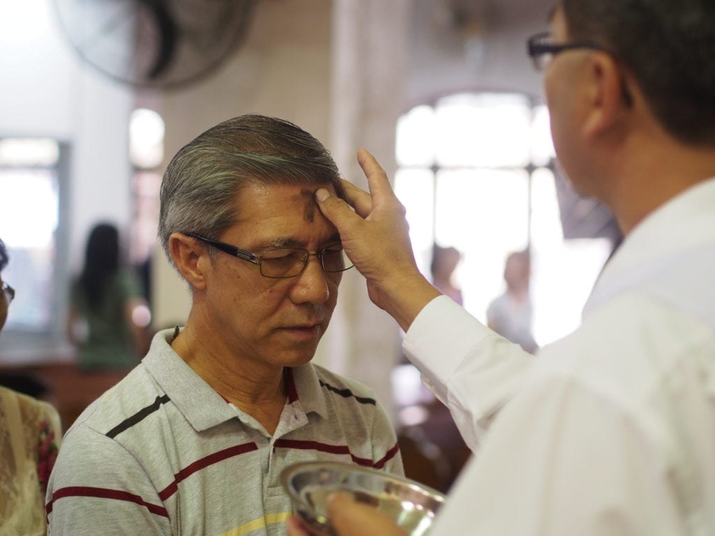 Communion Minister gives ashes to a parishioner in a form of a Cross on his forehead at at St. Ignatius Church on Ash Wednesday, Feb. 18, 2015. JOHN RAGAI/FLICKR VIA CC BY 2.0