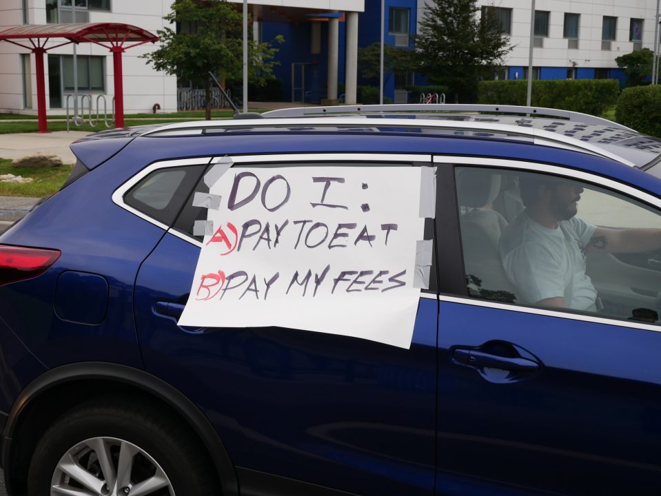 A sign that says, Do I: A) Pay To Eat B) Pay My Fees shown on a car during the graduate studentALEK LEWIS/THE STATESMAN