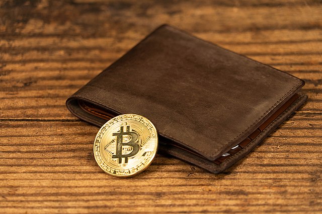 A photo of a bitcoin resting on a wallet.  CRYPTO WALLET/ WIKIMEDIA COMMONS VIA LICENSE