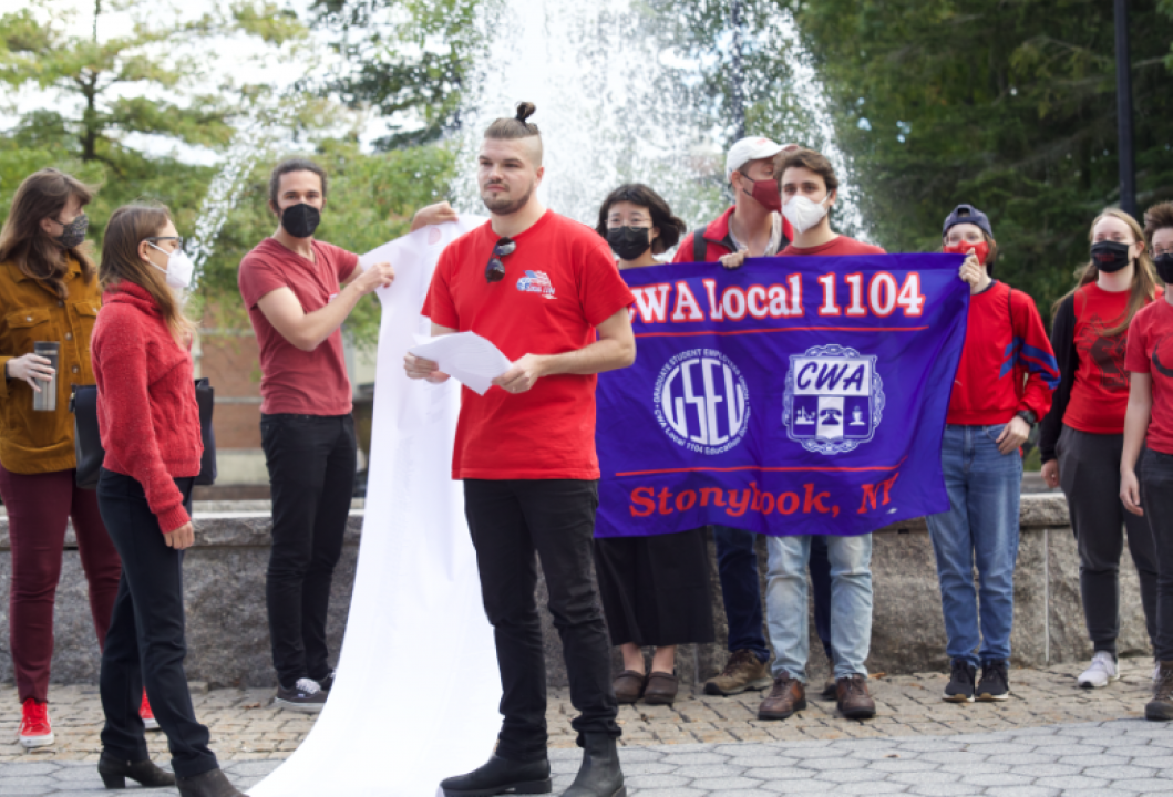 GSEU SBU hand-delivers a 10-foot-long petition demanding graduate workers be paid a living wage