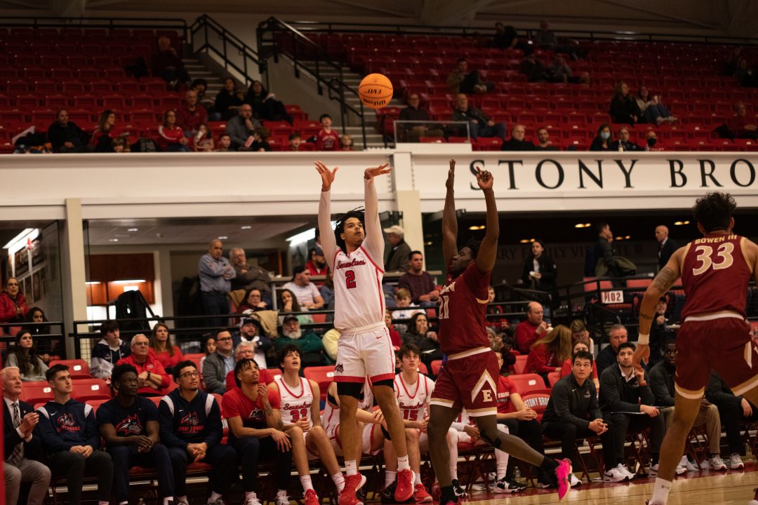 Forward Frankie Policelli shooting a three-pointer from the corner as a defender closes in against Elon Thursday, Feb. 3. A depleted Stony Brook mens basketball team was outmatched in the Battle of Long Island against Hofstra on Saturday. CAMRON WANG/THE STATESMAN