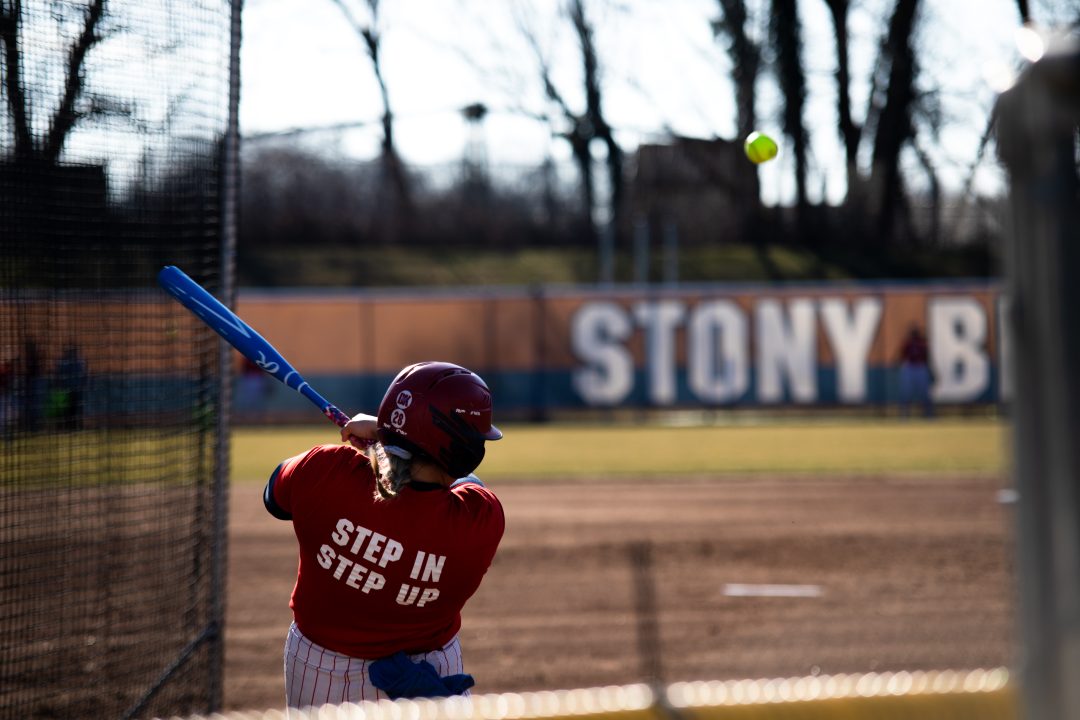 Catcher Corinne Badger launches a pitch in batting practice on Wednesday, Feb. 8. Badger caught a pair of complete games on Thursday in the Stony Brook softball teams sweep of Sacred Heart. TIM GIORLANDO/THE STATESMAN
