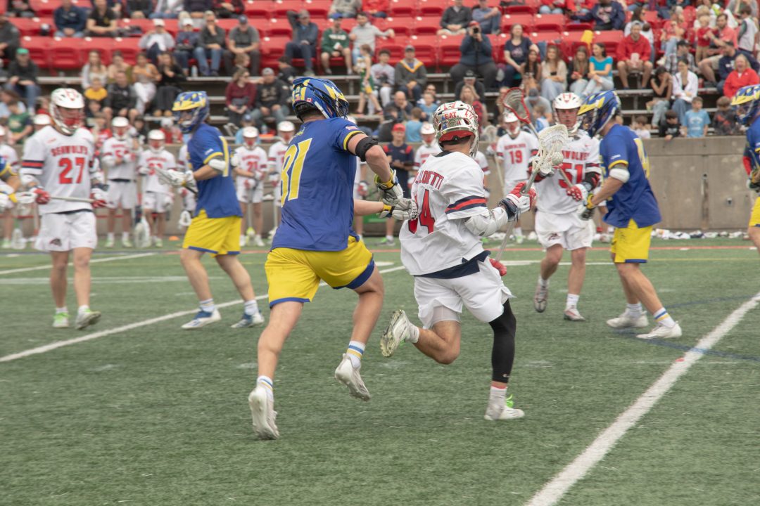 Attackman Dylan Pallonetti (34) dodges Delaware defender Owen Grant while midfielders Sean Carlo (27) and Matt Anderson (51) try to create space on Saturday, April 15. Pallonetti and Grant are two of the best in the nation and will go head-to-head for the CAA title on Saturday. TIM GIORLANDO/THE STATESMAN
