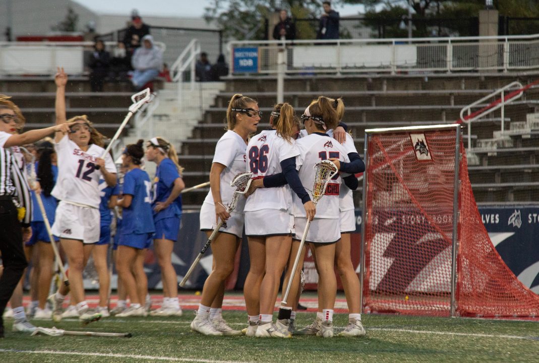 Several Stony Brook womens lacrosse players in a huddle during a timeout against Hofstra on Friday, April 28. The Seawolves won their first-ever CAA tournament on Saturday at the Towson Tigers. VIKRAM SETHI/THE STATESMAN