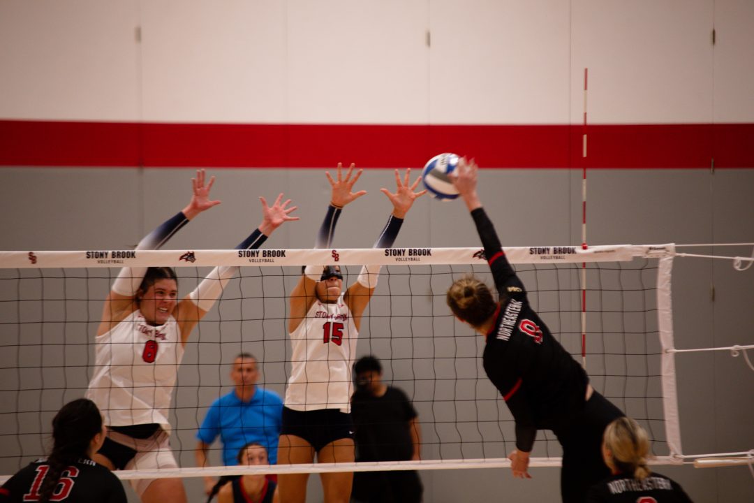 Middle blocker Abby Campbell (left) and outside hitter Kali Moore (right) leap to block an attack by a Northeastern player on Saturday, Sept. 16. Campbell and Moore led the Stony Brook womens volleyball team to a split at Charleston. BRITTNEY DIETZ/THE STATESMAN