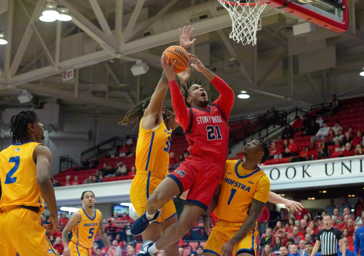 Power forward Andre Snoddy takes a contested layup through two Hofstra defenders on Monday, Jan. 22. Snoddy posted his first double-double with Stony Brook on Monday night. BRITTNEY DIETZ/THE STATESMAN