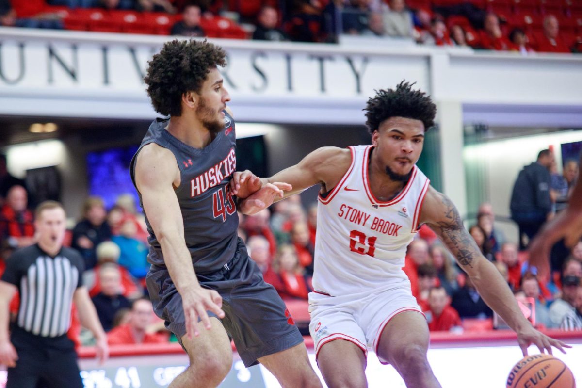 Power forward Andre Snoddy drives through Northeastern center Collin Metcalf on Saturday, Feb. 3. Snoddys performance on the glass tomorrow versus Hampton will be crucial in the Stony Brook mens basketball teams hopes for victory. MACKENZIE YADDAW/THE STATESMAN