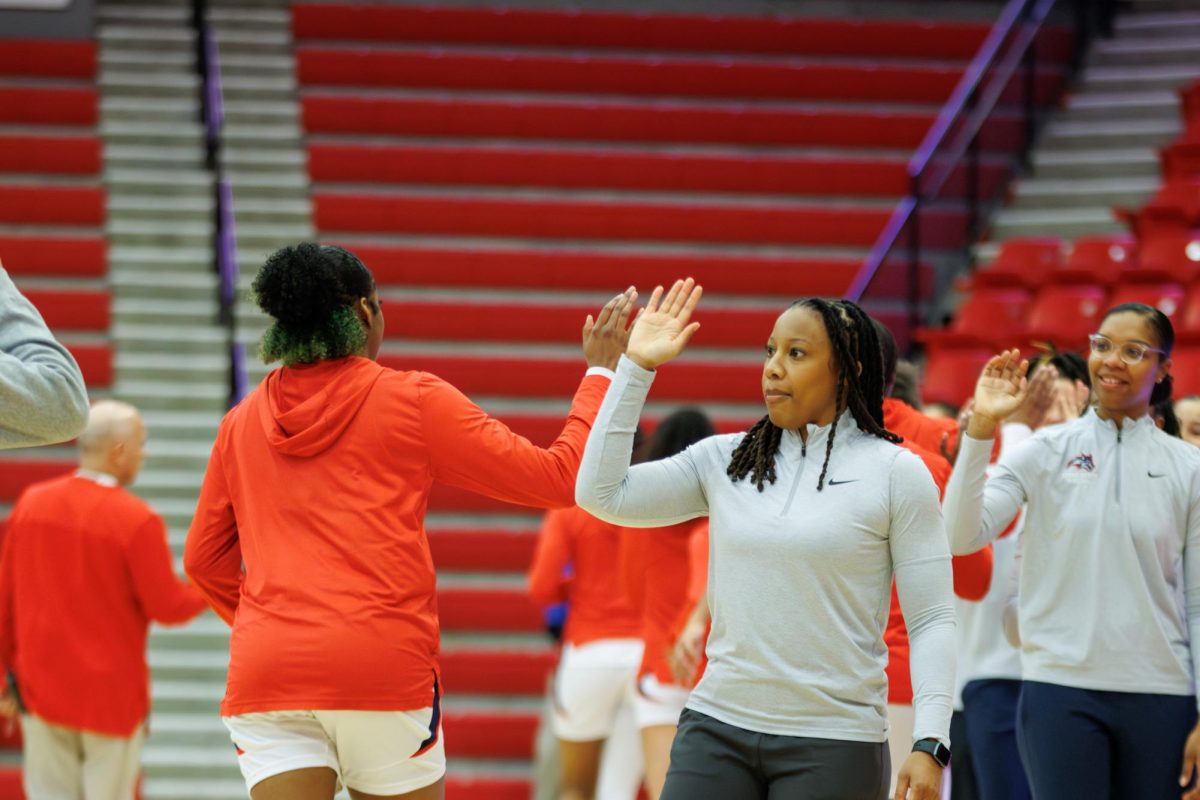 Head coach Ashley Langford (foreground) high-fives her players as they walk towards the tunnel before a game against Hofstra on Friday, Feb. 16. Langfords team will host the Elon Phoenix tomorrow. STANLEY ZHENG/THE STATESMAN