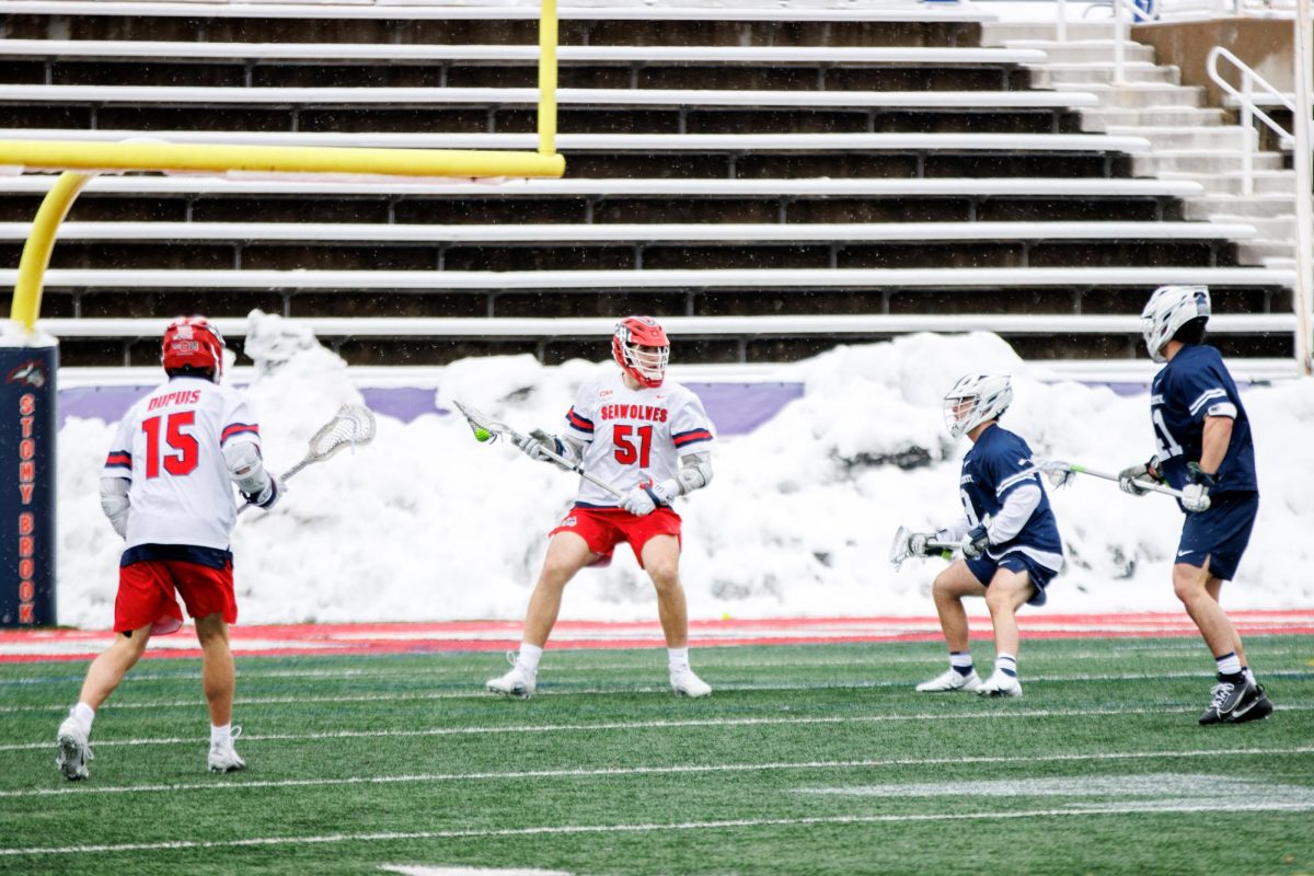 Midfielder Ryan Barker (51) operates the offense from the X while attackman Nick Dupuis (15) looks on. Both players scored two goals at Air Force on Saturday. STANLEY ZHENG/THE STATESMAN