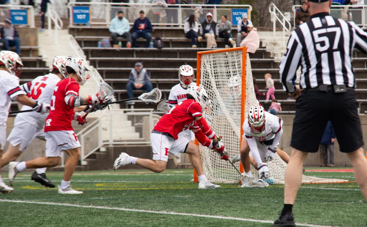 Goalkeeper Tommy Wilk (right) controls a ground ball over Rutgers attackman Tanyr Krummenacher on Saturday, Feb. 5. Wilk made his NCAA debut on Saturday and saved 12 shots in 20 chances. BRITTNEY DIETZ/THE STATESMAN