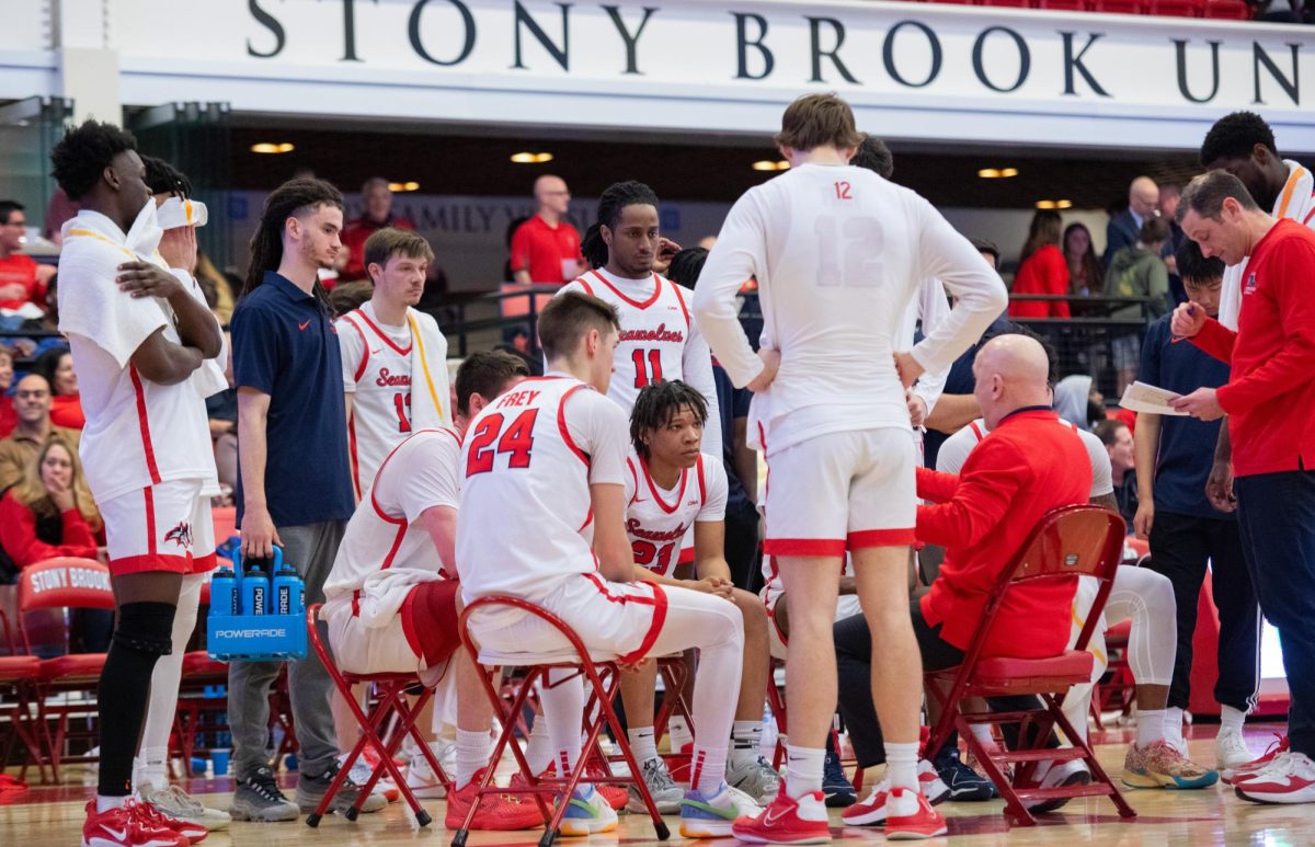 The Stony Brook mens basketball team gathers around head coach Geno Ford (right) during a timeout against North Carolina A&T on Thursday, Feb. 22. The Seawolves will host William & Mary tomorrow afternoon. MACKENZIE YADDAW/THE STATESMAN