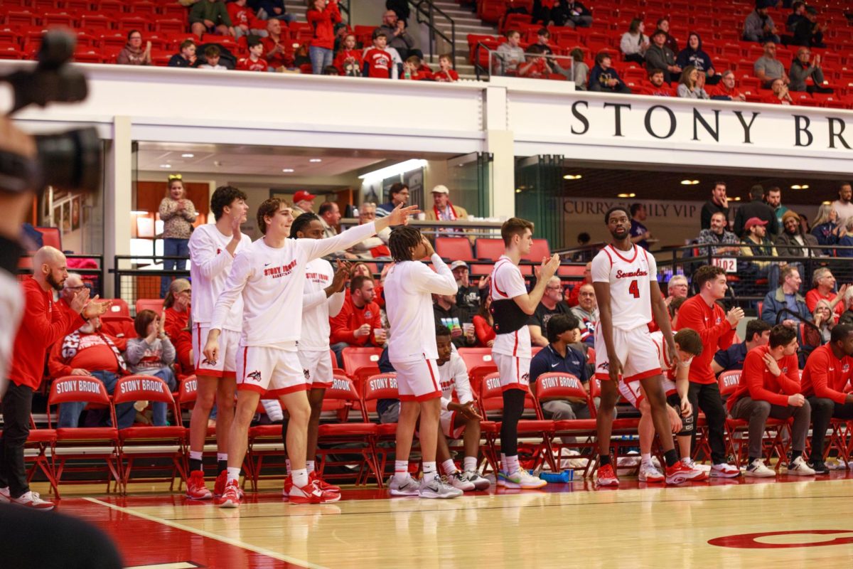 Several Stony Brook mens basketball players celebrate a play against Delaware on Saturday, March 2. The Seawolves will play Drexel in the quarterfinals of the postseason tournament tomorrow evening. ANGELINA LIVIGNI/THE STATESMAN