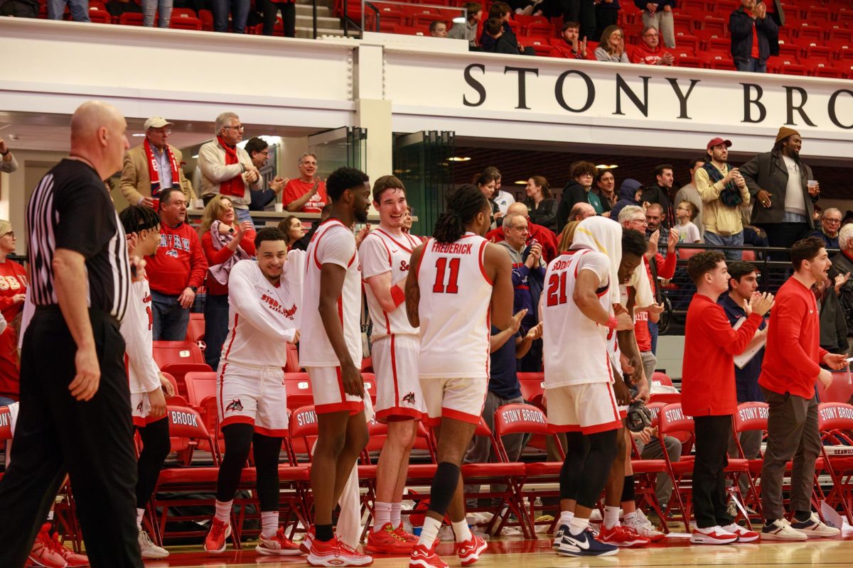 Several Stony Brook mens basketball players celebrate on the sideline against Delaware on Saturday, March 2. The Seawolves will begin their 2024 postseason run on Friday against Northeastern. ANGELINA LIVIGNI/THE STATESMAN