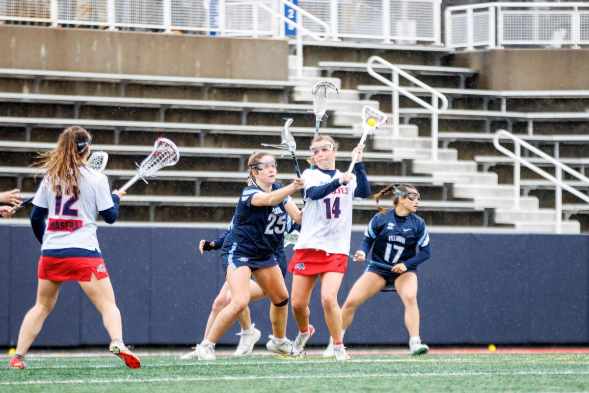 Attacker Kailyn Hart (14) passes the ball to midfielder Ellie Masera (12) against Villanova on Saturday, March 2. Hart and Masera co-led the Stony Brook womens lacrosse team with five points apiece on Saturday against Johns Hopkins. STANLEY ZHENG/THE STATESMAN