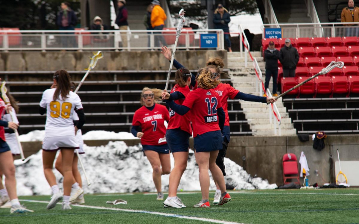 Four Stony Brook womens lacrosse players celebrate a goal against Arizona State on Feb. 23. The Seawolves will host Elon tomorrow for their second conference game of the year. BRITTNEY DIETZ/THE STATESMAN