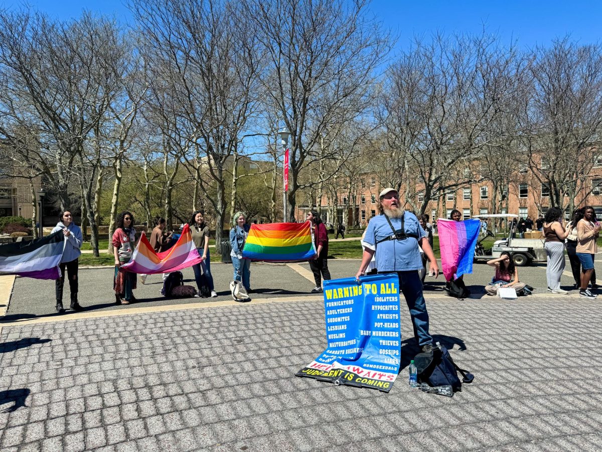 The preacher guy preaching to students at the Students Activity Center Plaza while students hold up LGBTQ+ flags on -- PHOTO COURTESY OF GABRIELLA CAVALCANTE