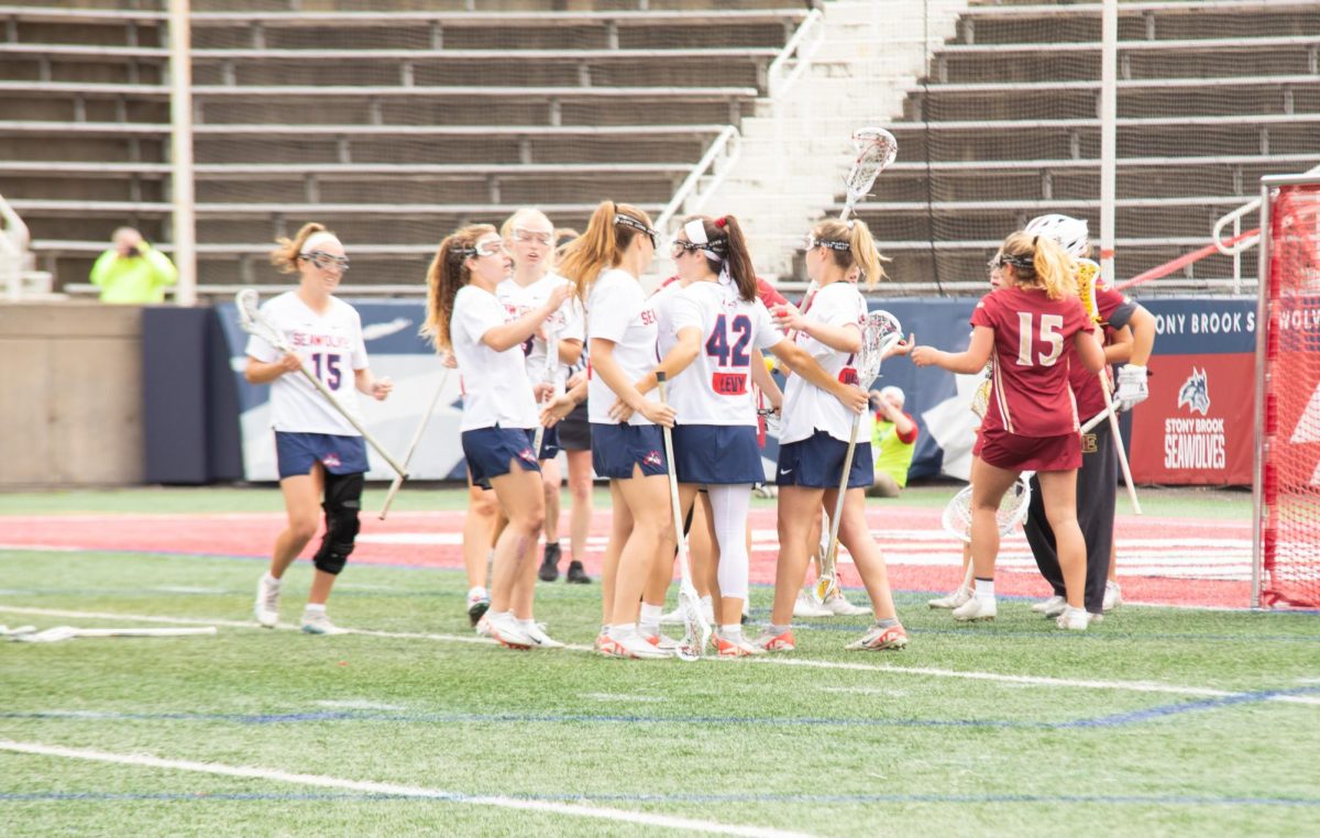 Players from the Stony Brook womens lacrosse team celebrate a goal in their semifinal victory over Elon on Thursday, May 2. The Seawolves will now square off against Drexel with the CAA championship on the line at Kenneth P. LaValle Stadium on Saturday. IRENE YIMMONGKOL/THE STATESMAN